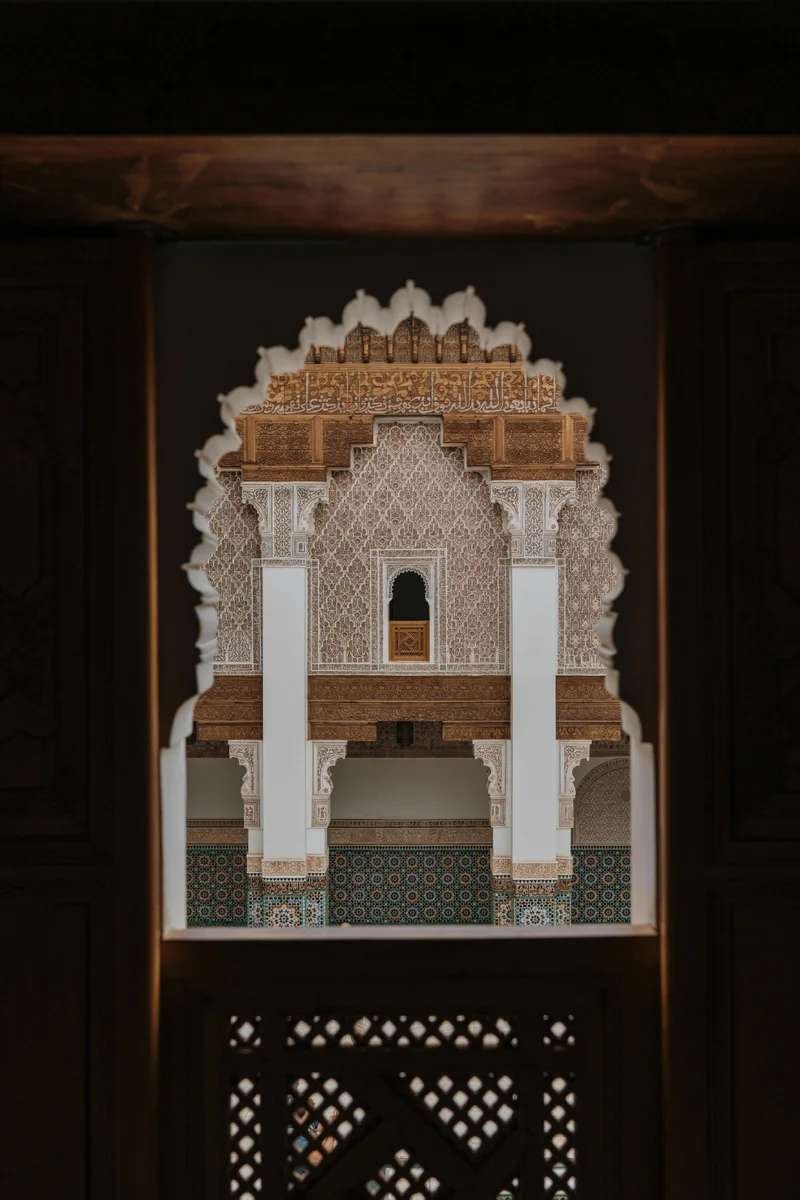 View through ornate arch framing the inner courtyard of Ben Youssef Madrasa.