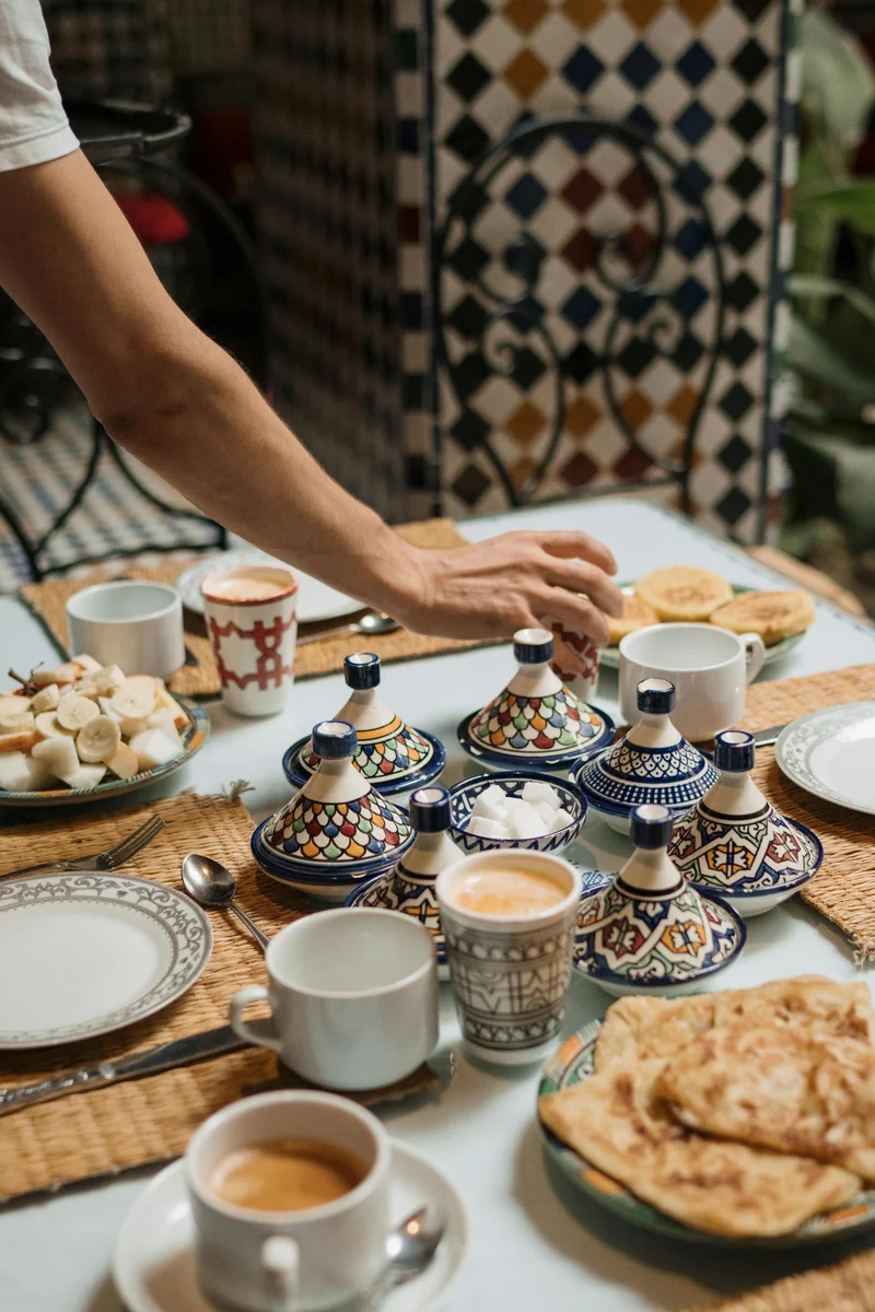 Traditional Moroccan breakfast with tagines and mint tea showing riad hospitality standards