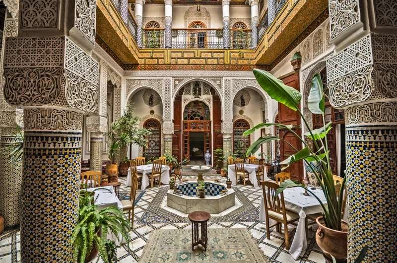 Traditional Moroccan riad courtyard with ornate archways and central fountain