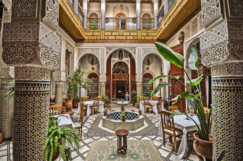 Traditional Moroccan riad courtyard with ornate archways and central fountain