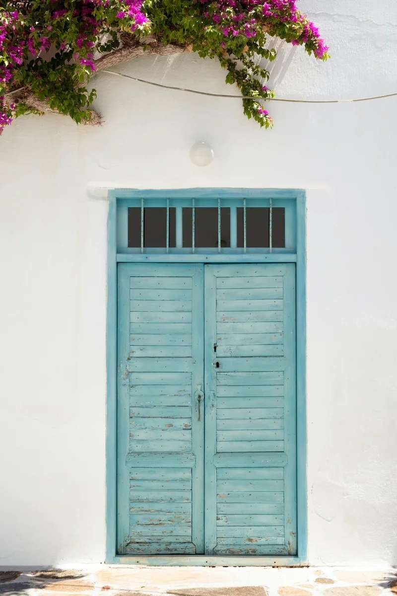 White wall with turquoise door and pink bougainvillea - coastal Morocco charm