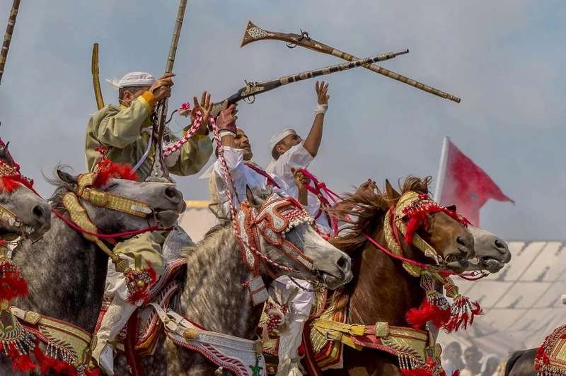 Moroccan fantasia horse riders in traditional dress representing authentic cultural travel experiences