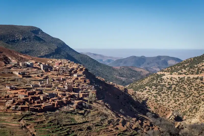 Amazigh village in the Atlas Mountains during spring, when green valleys contrast with snow-capped peaks