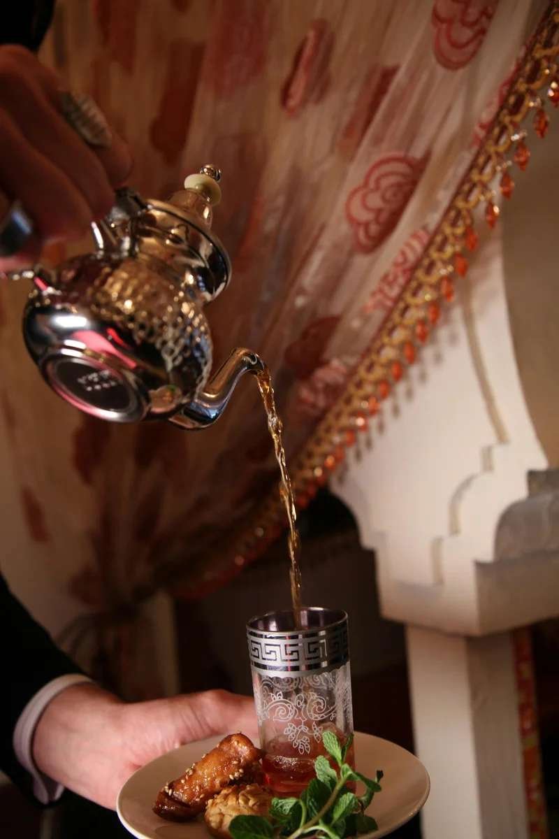 Traditional Moroccan mint tea ceremony with ornate silver teapot - intimate cultural experience