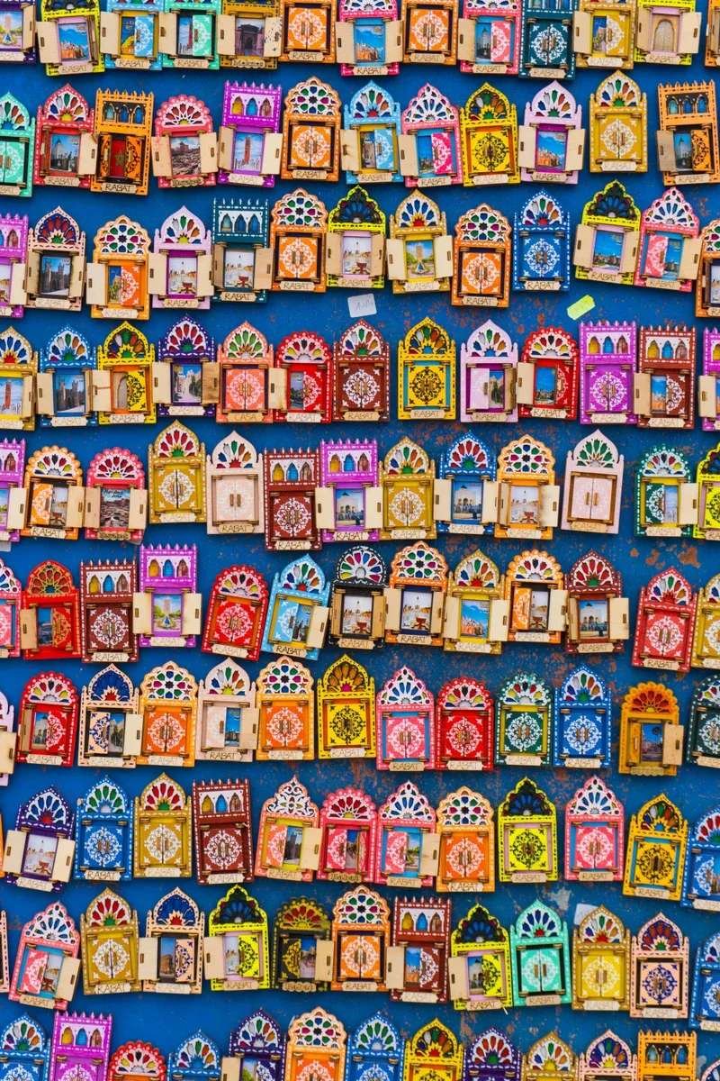 Vibrant display of colorful decorative Moroccan souvenir frames and mirrors in a Marrakech souk showing the variety of crafts available in the markets